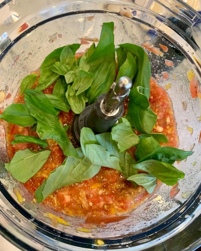 adding basil to the tomato caprese gazpacho