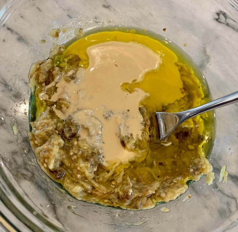 stirring the baba with tahini and olive oil